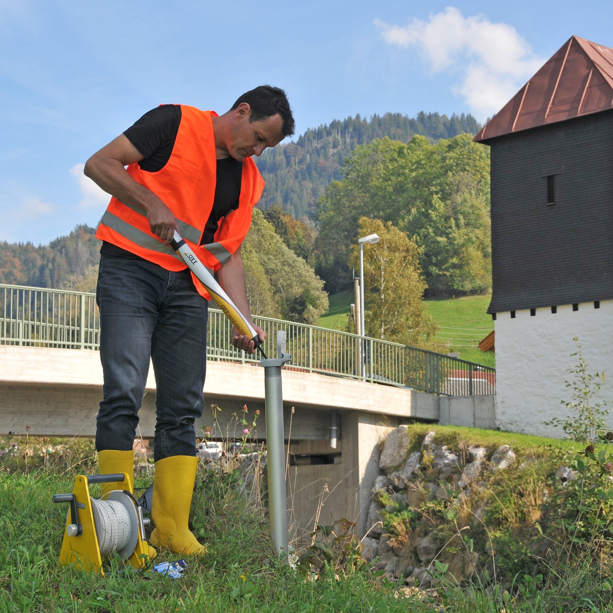 hydrologist deploying a water level sensor into a well